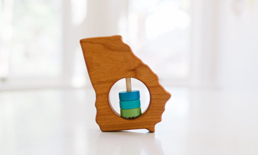 Georgia state-shaped cherry wood baby rattle with colored center disks