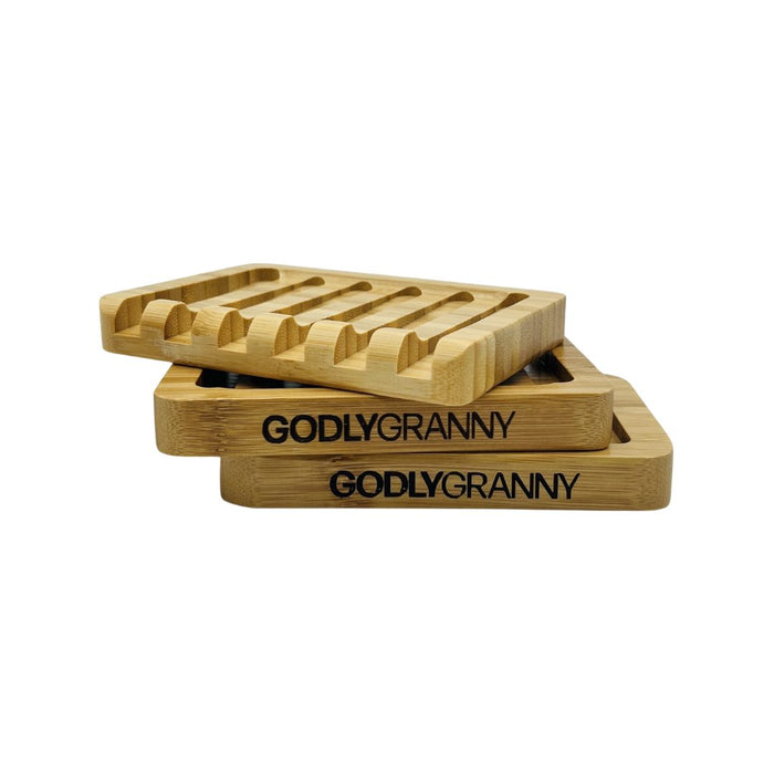 Two slotted bamboo soap dishes with engraved brand logos