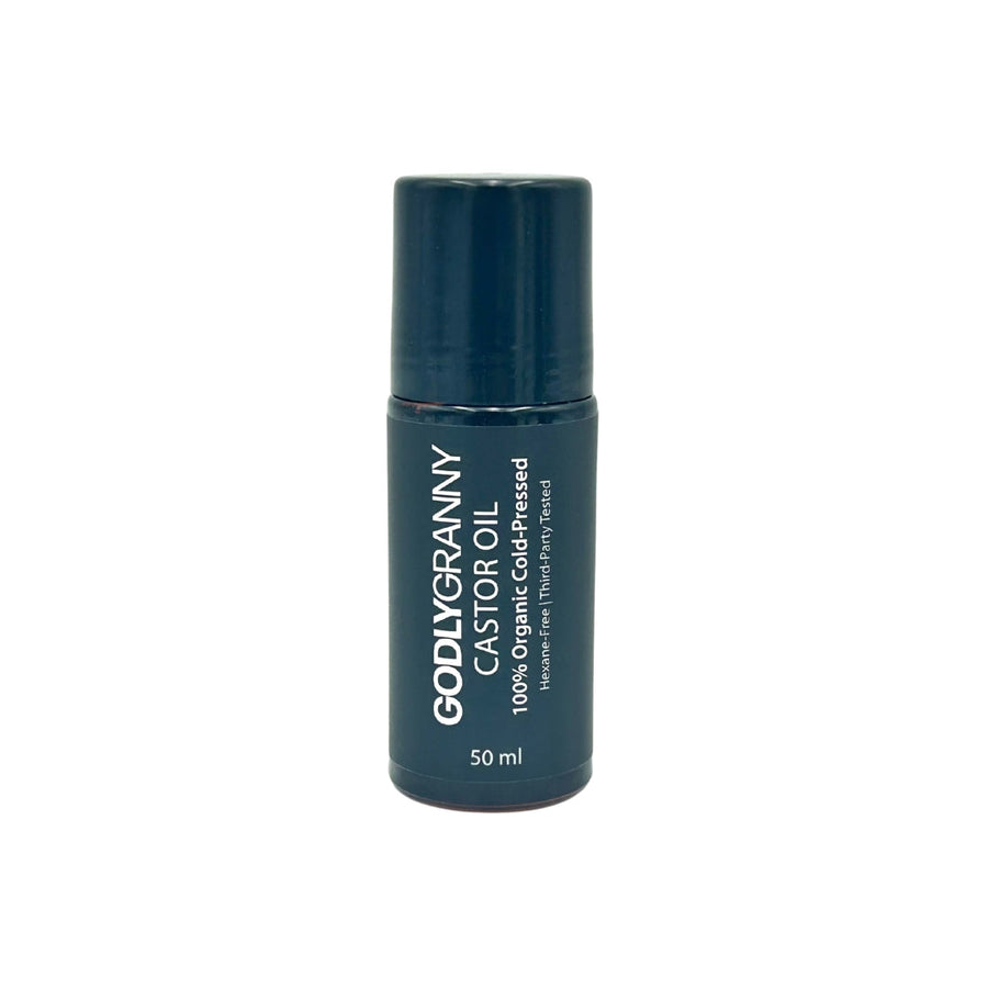 Amber castor oil roller bottle with its dark cap alongside