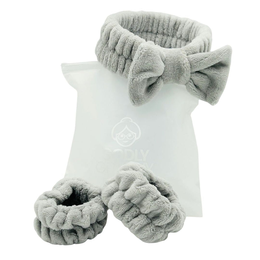 Gray bow headband and wristbands arranged with a logo storage bag