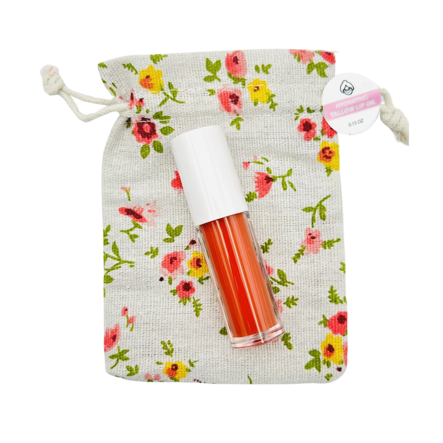 Tallow lip oil roller bottle with a floral drawstring storage bag