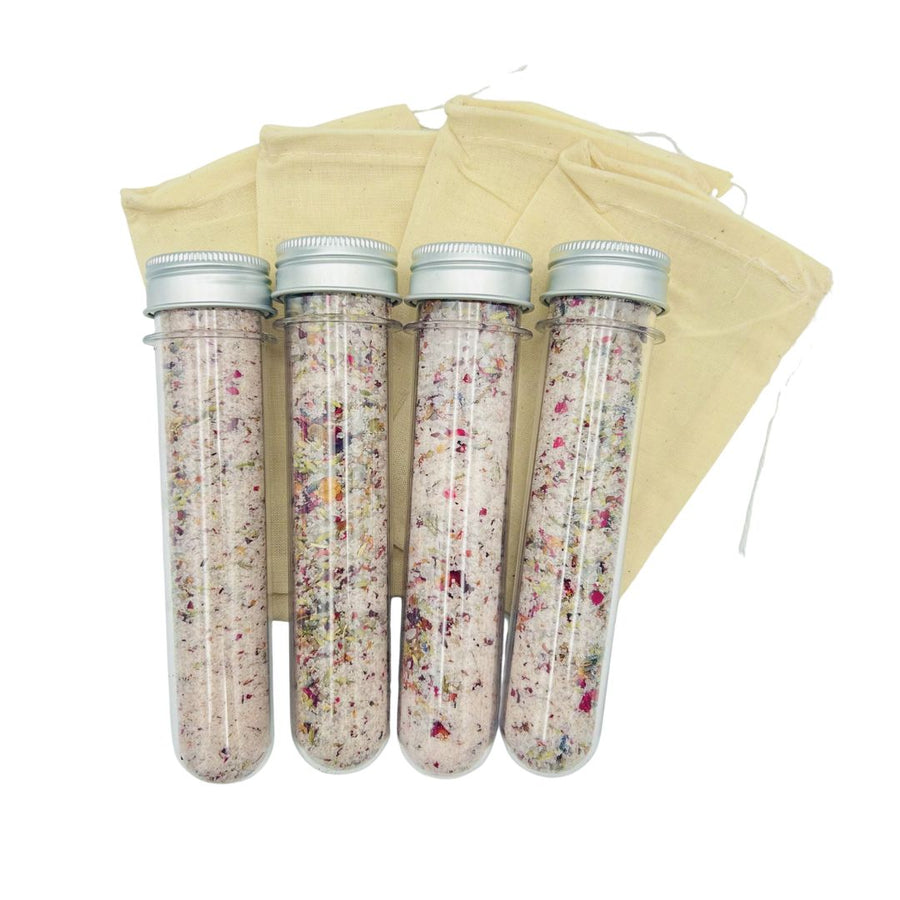 Four botanical bath-salt vials with silver-colored caps and muslin bags