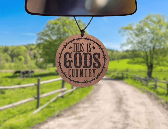 Round God's Country leather car air freshener with lettering and a barbed-wire-style border