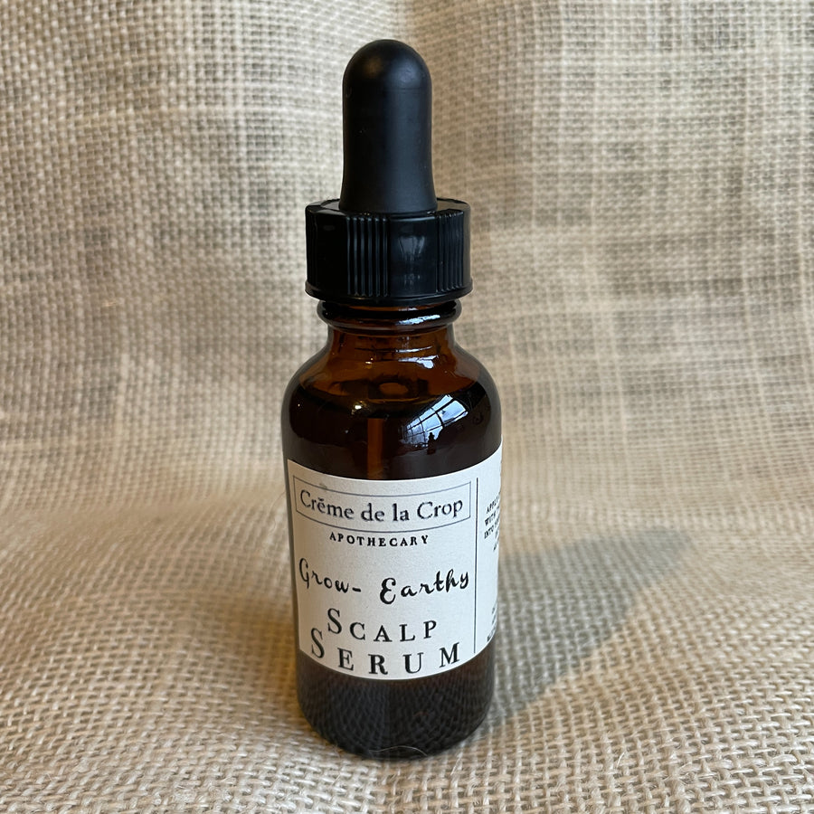 Earthy Grow scalp serum in an amber dropper bottle
