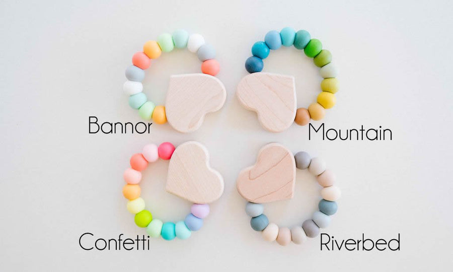 Heart charm teether examples showing several silicone bead color combinations