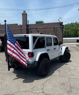 Heavy-duty hitch mount flagpole with American flag installed on truck receiver