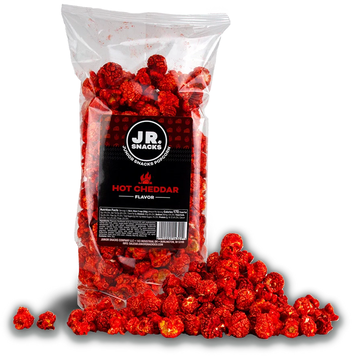 Hot Cheddar popcorn bag beside a pile of red seasoned popcorn