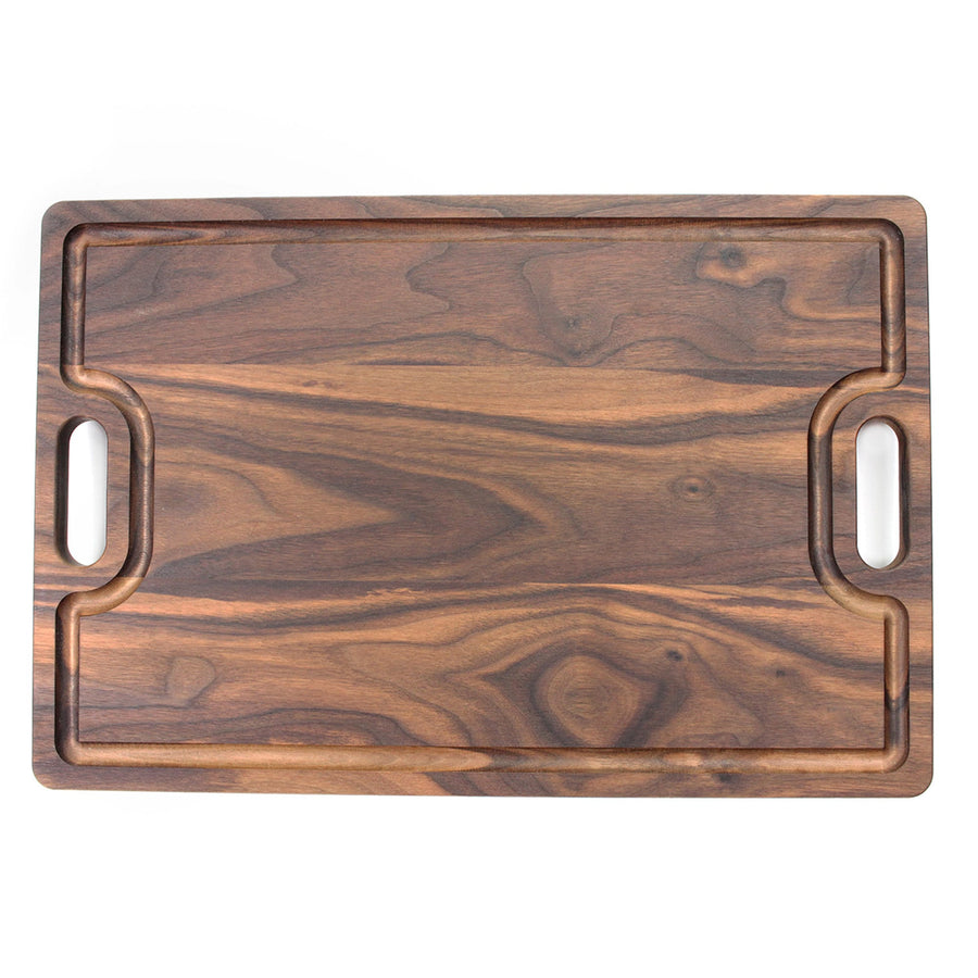 Overhead view of a walnut board with a juice groove and dual handles
