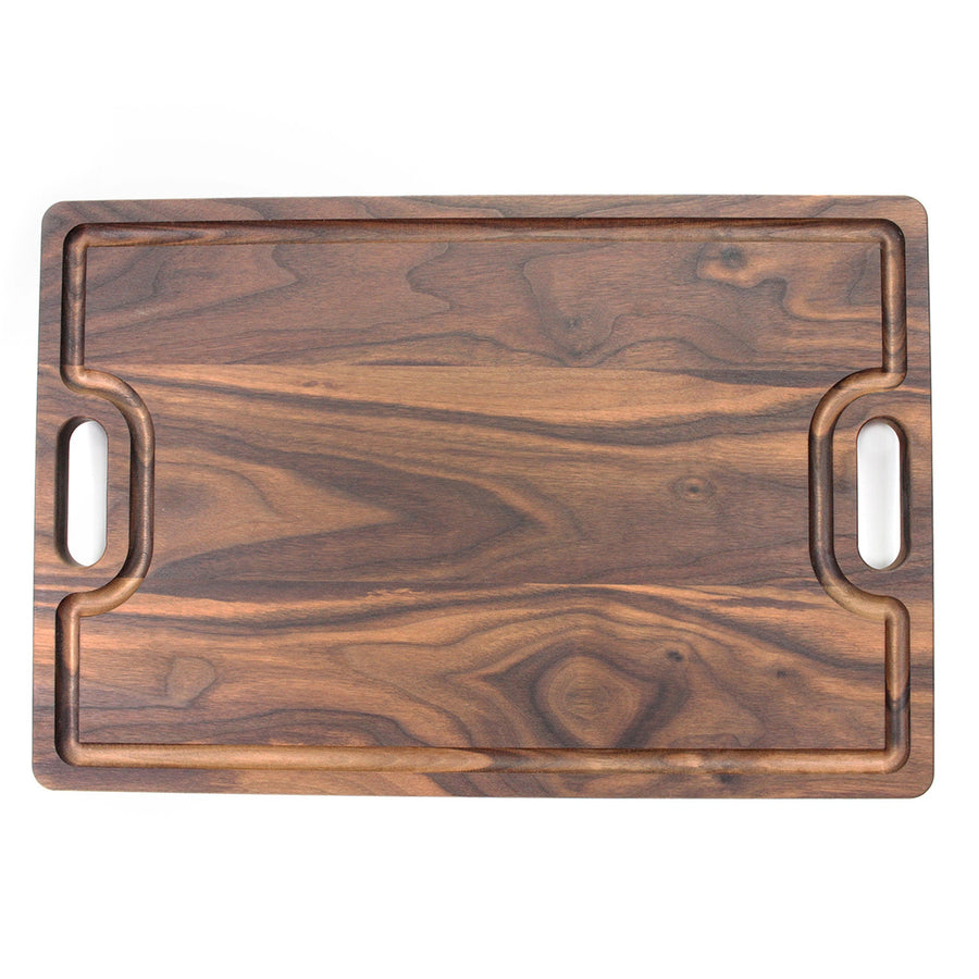 Overhead view of a walnut board with a juice groove and dual handles