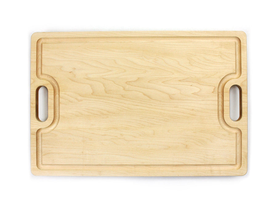 Maple cutting board with cutout handles and a shaped juice groove