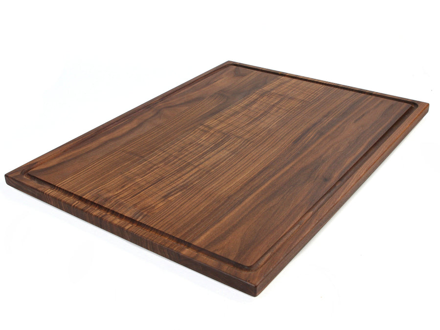 Walnut rectangular cutting board with a juice groove on a white background