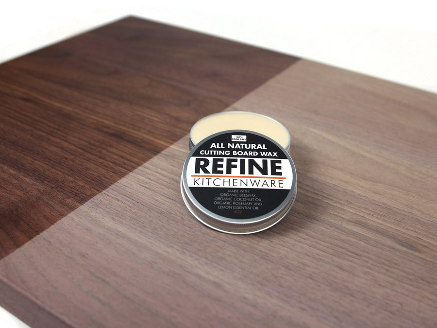 Cutting board wax tin on a two-tone wood surface
