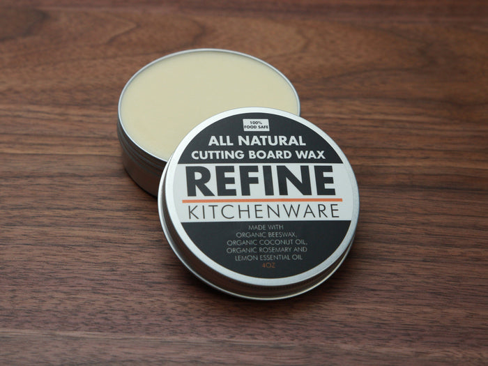 Open tin of cutting board wax showing the pale conditioner and labeled lid
