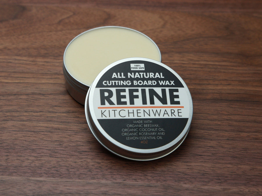 Open tin of cutting board wax showing the pale conditioner and labeled lid