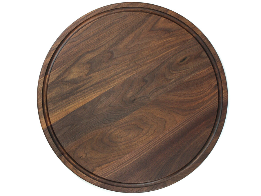 Overhead view of a round walnut board with a circular juice groove