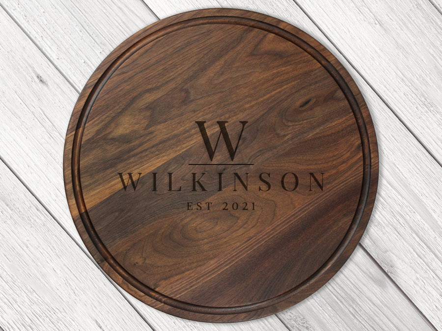 Round walnut board with a surname and established-date engraving