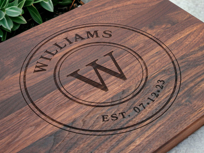 Circular monogram and family-name engraving on a walnut cutting board