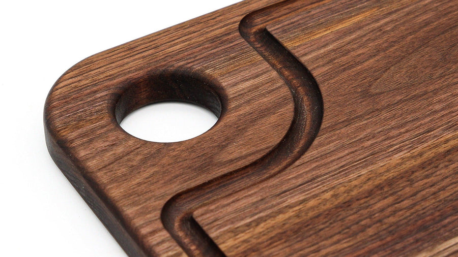 Walnut thumb-hole board detail showing the circular opening and channel