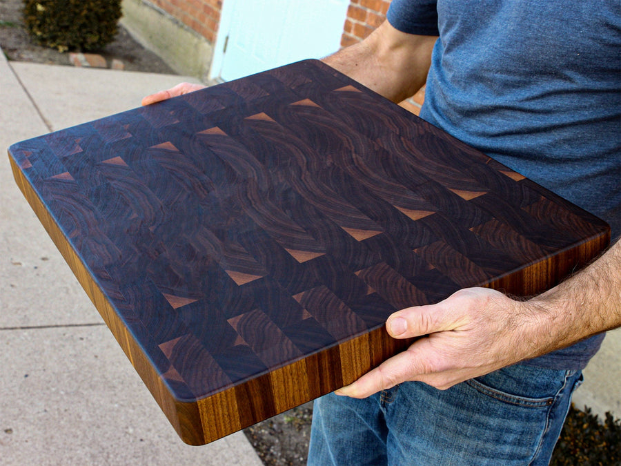Person carrying a thick walnut end-grain butcher block
