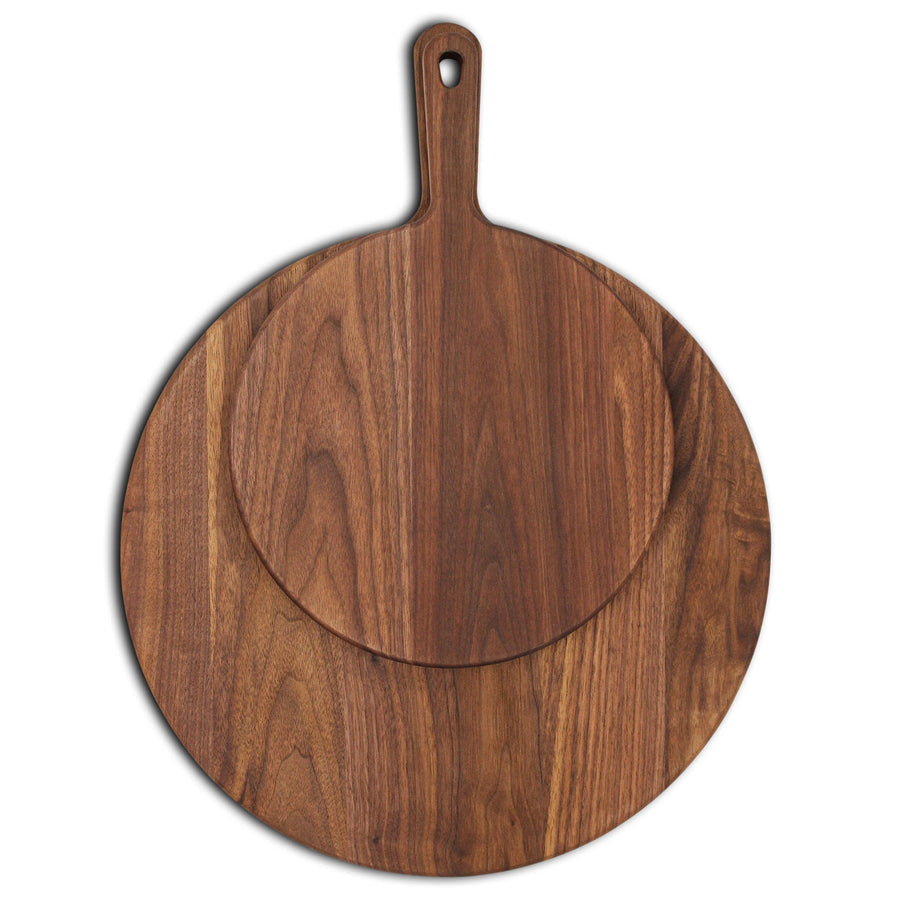 Small and large round walnut paddle boards stacked to compare sizes