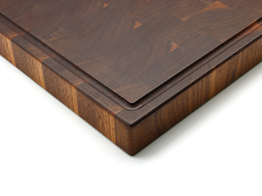 Close view of a thick walnut end-grain board and juice groove