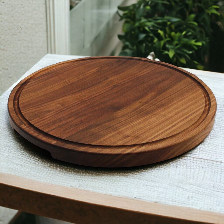 Thick round walnut cutting board with a circular juice groove