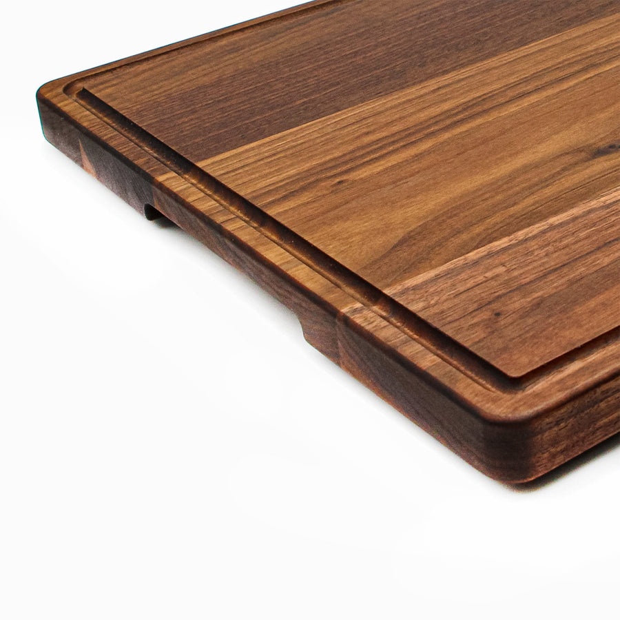Close view of a walnut board's juice groove and rounded edge