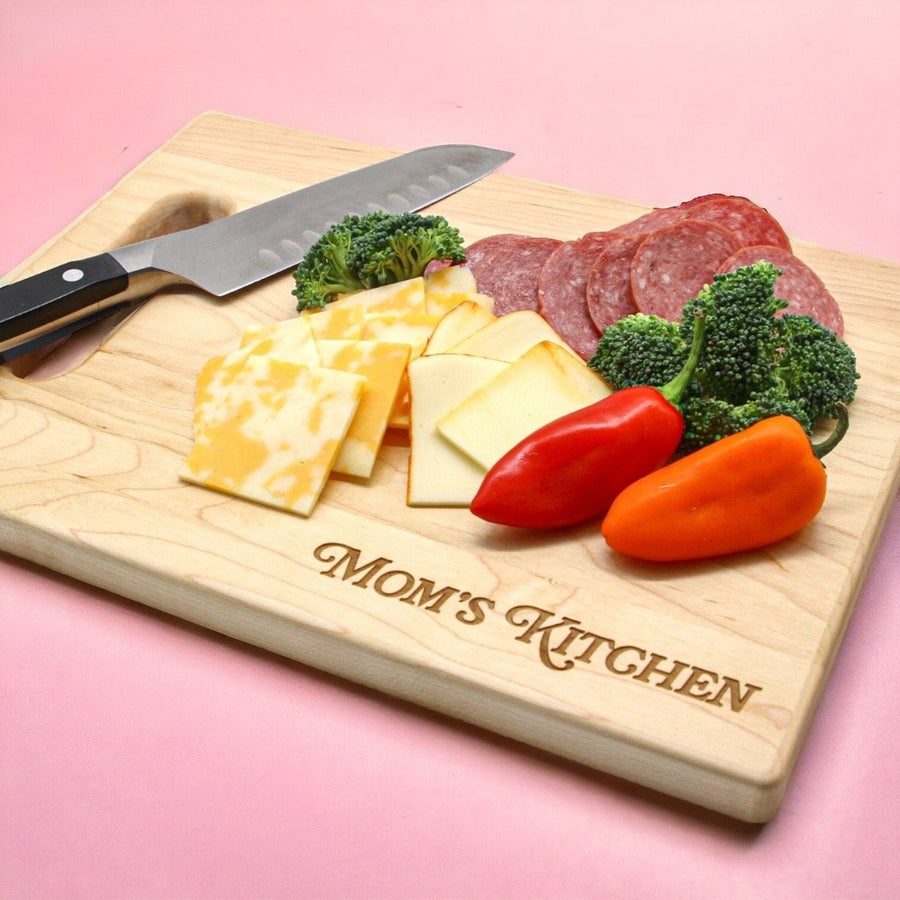 Personalized Mom's Kitchen maple board with a knife, cheese and vegetables
