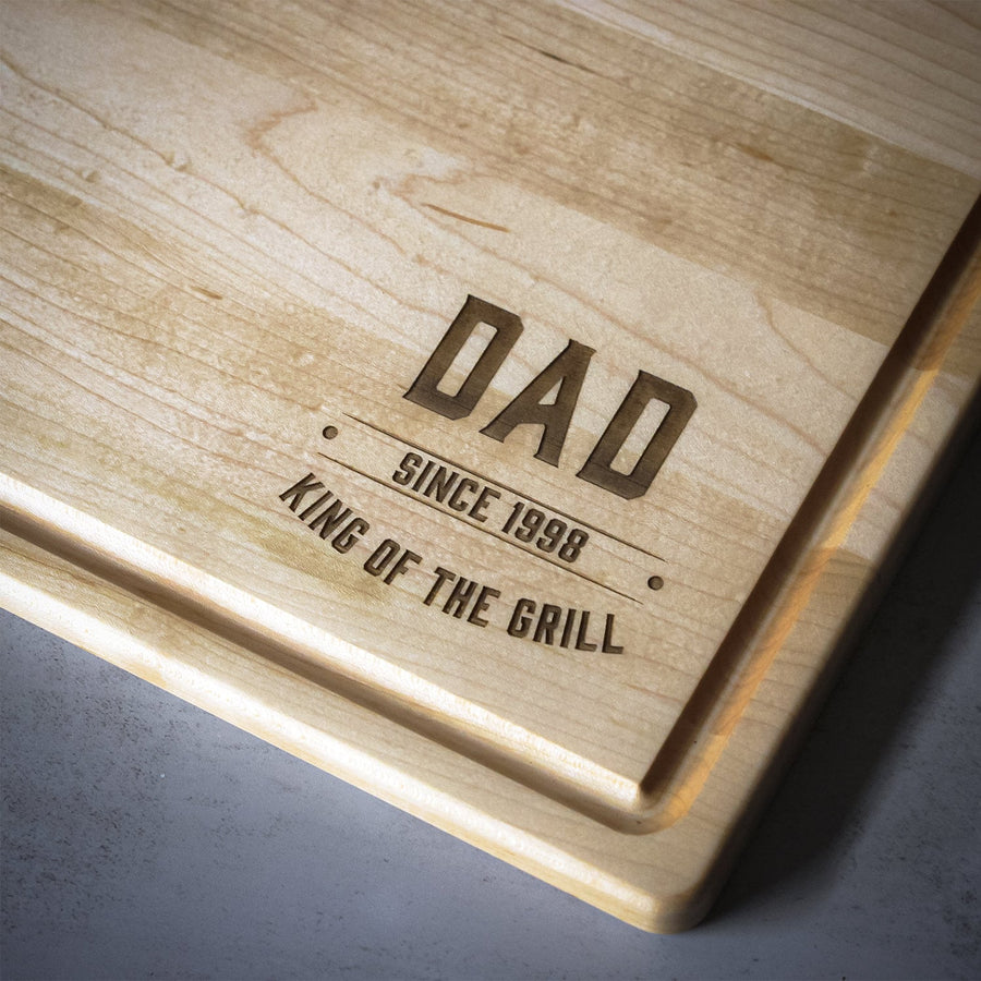 Maple cutting board engraved with a Dad King of the Grill design