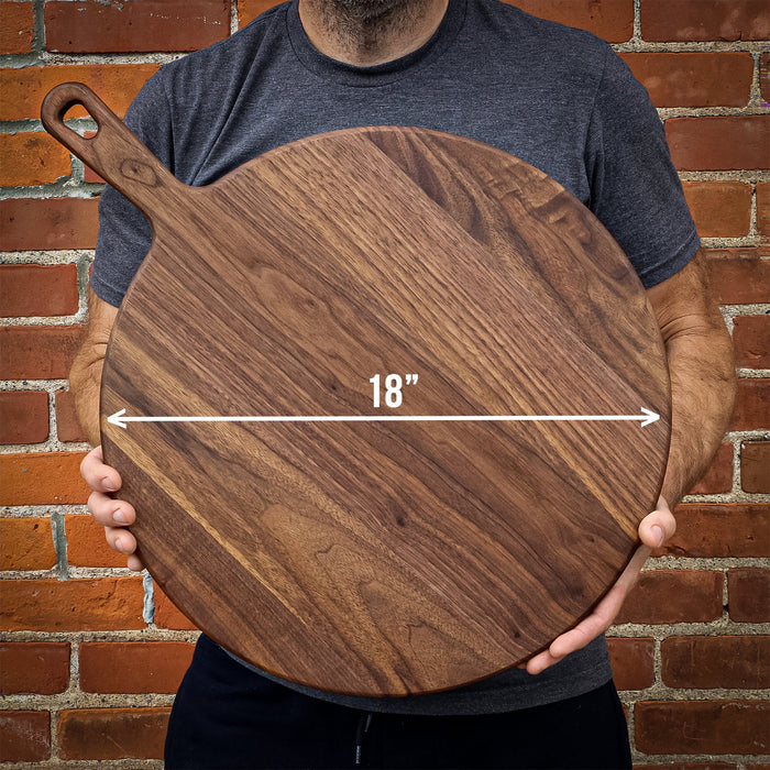 Person holding a large round walnut paddle board with an 18-inch dimension marked