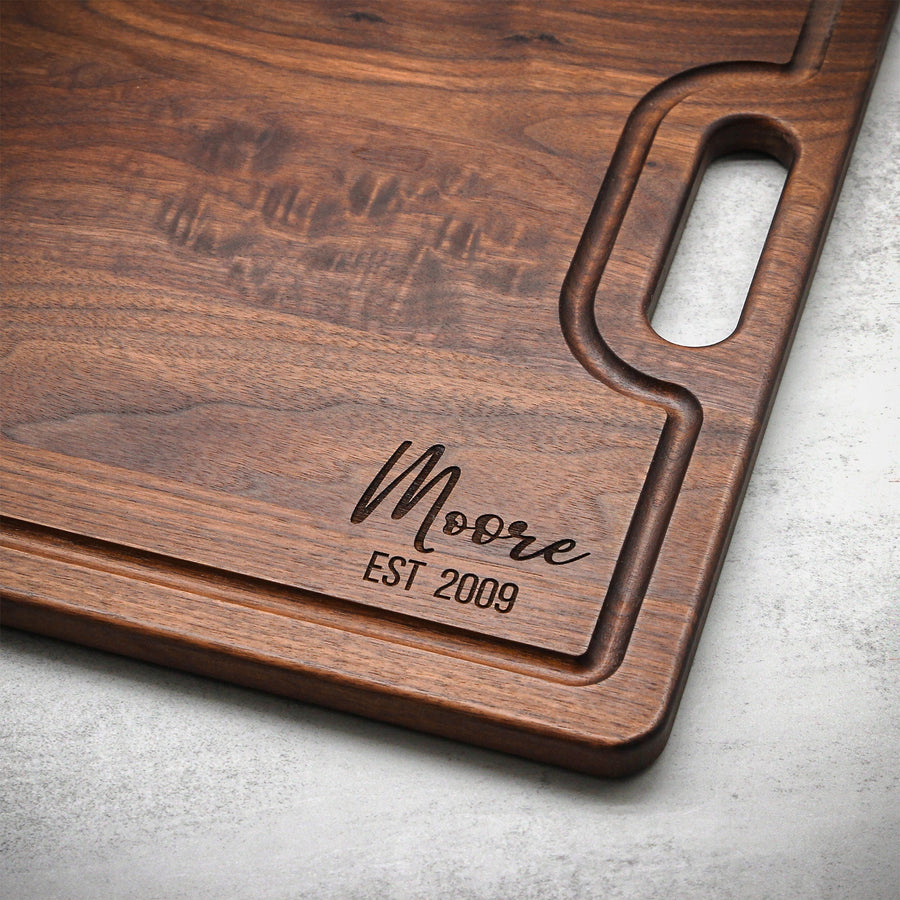 Walnut board handle detail with a personalized surname and established date