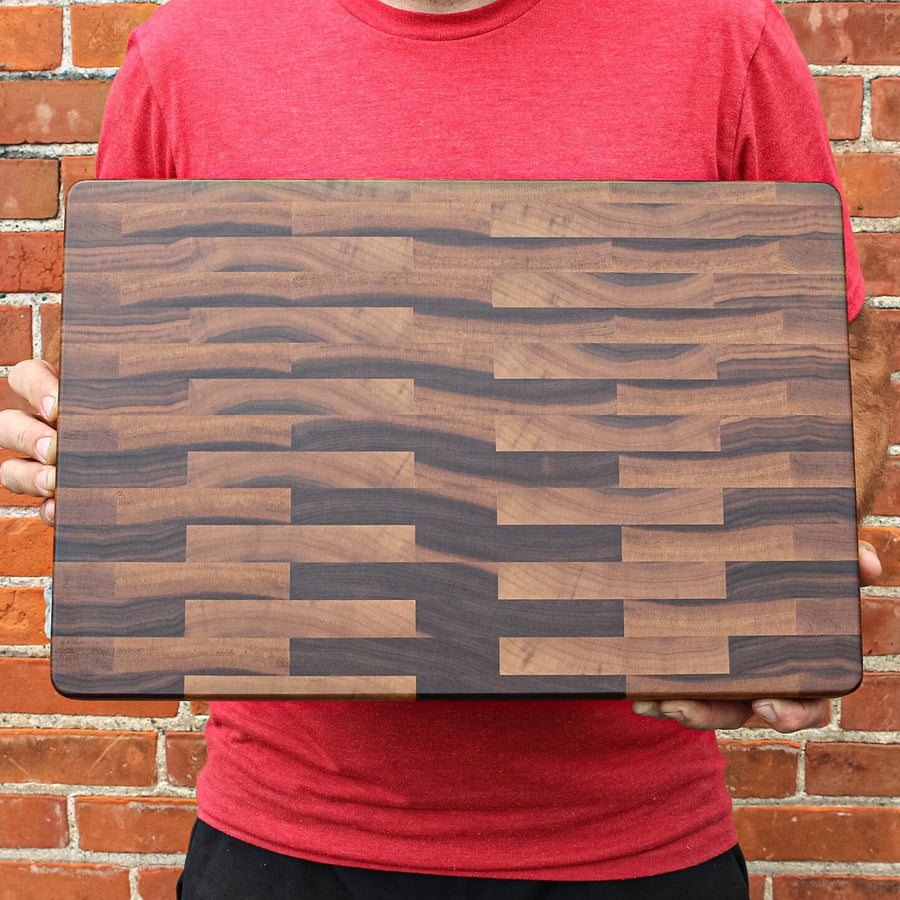 Person holding a rectangular calico walnut end-grain butcher block
