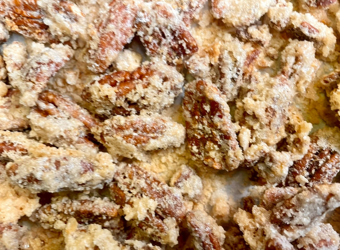 Close-up of Lemon Pound Cake candied pecans with a pale, textured coating