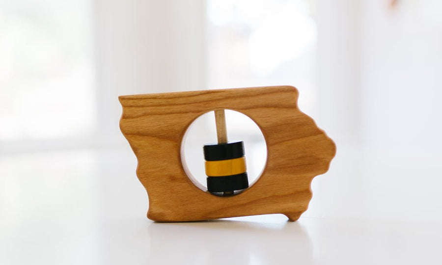 Iowa state-shaped cherry wood baby rattle with colored center disks