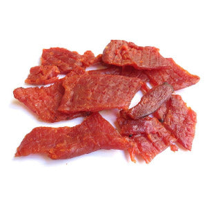 Pieces of red-brown pork jerky on a white background