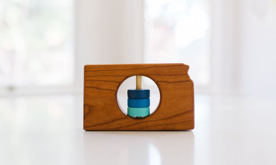 Kansas state-shaped cherry wood baby rattle with colored center disks