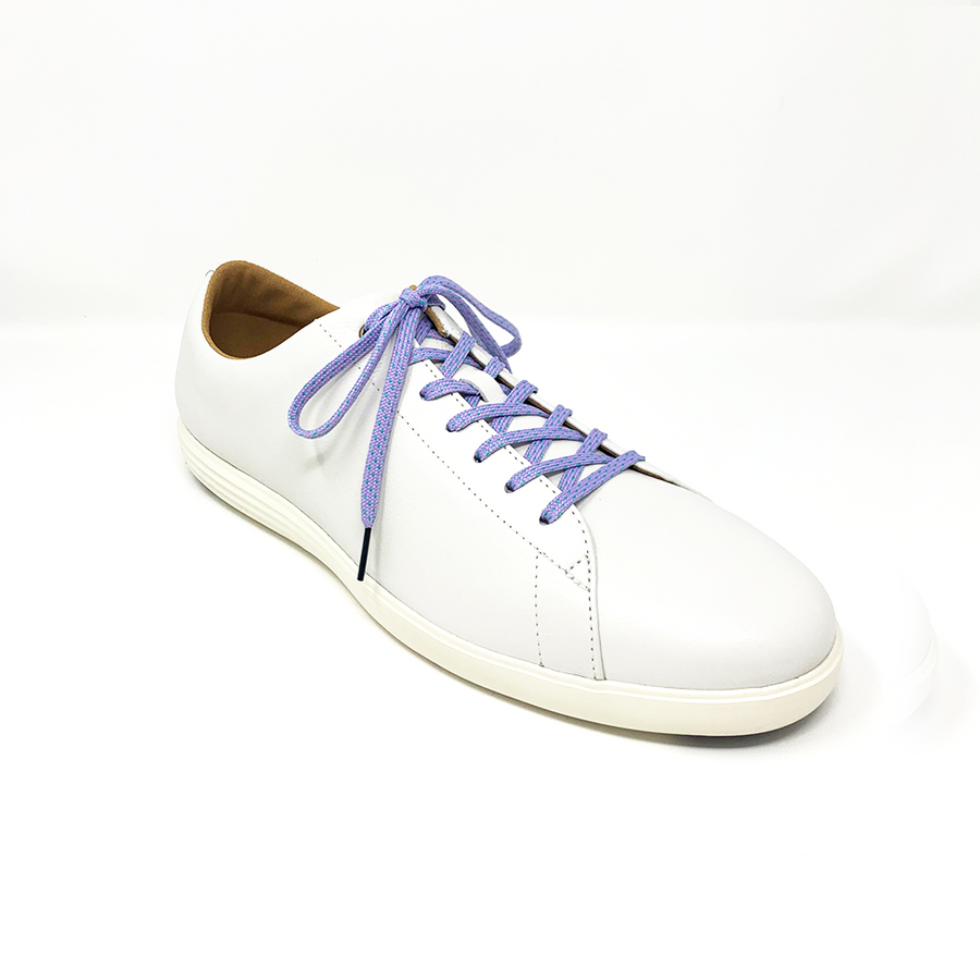 Lavender & Electric Green ticked flat shoelaces laced into a cream low-top sneaker