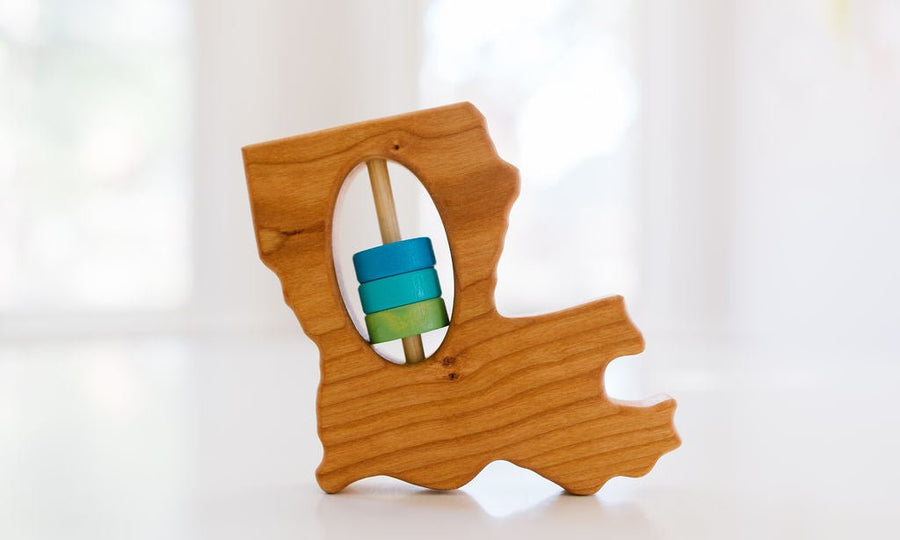 Louisiana state-shaped cherry wood baby rattle with colored center disks