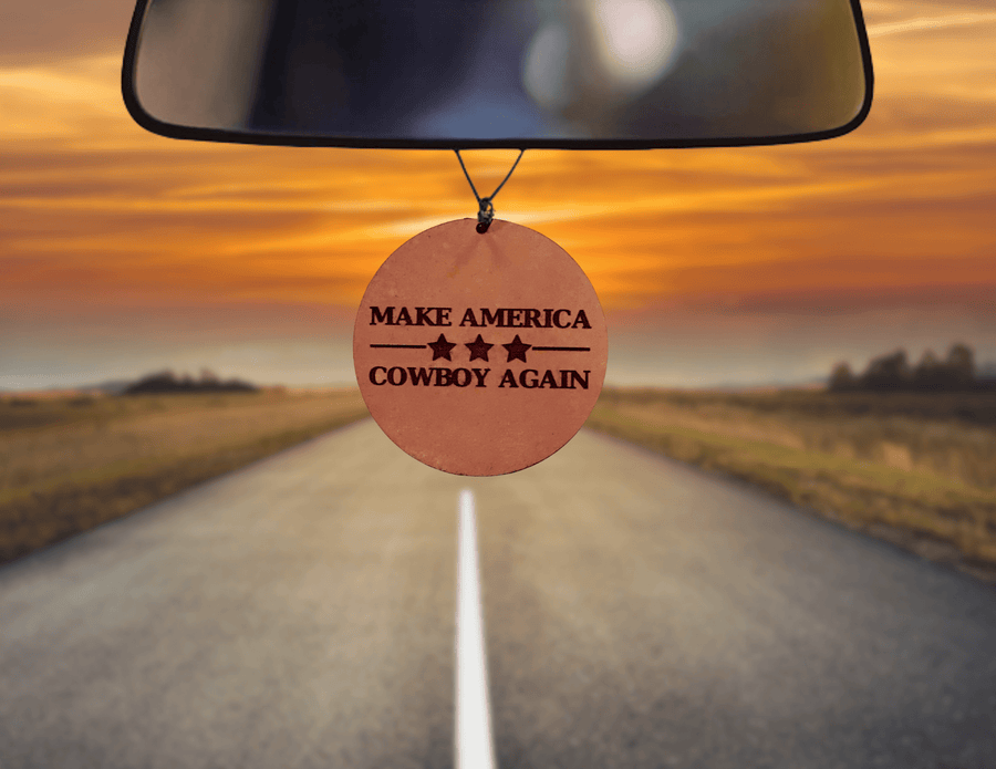 Round leather car freshener engraved with Make America Cowboy Again lettering
