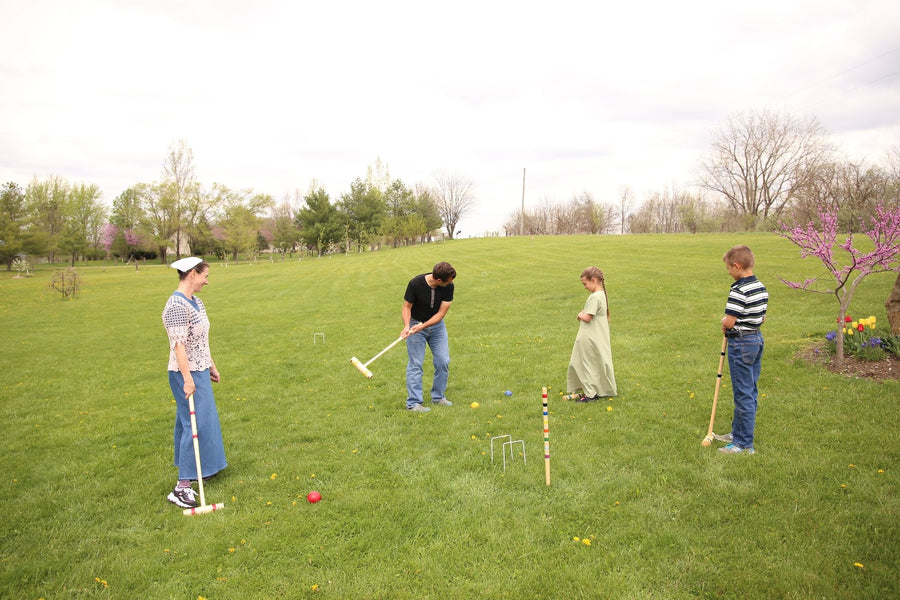 Family playing croquet together on a lawn
