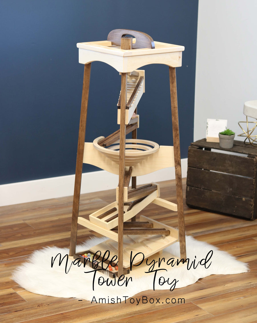 Tall wooden pyramid marble run displayed in a room