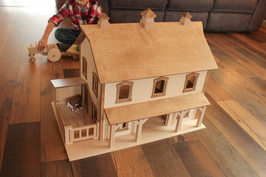 Child playing with a two-story wooden bank barn