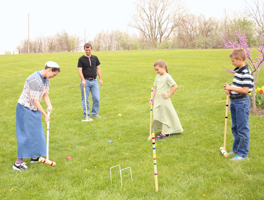 Family playing croquet together on a lawn