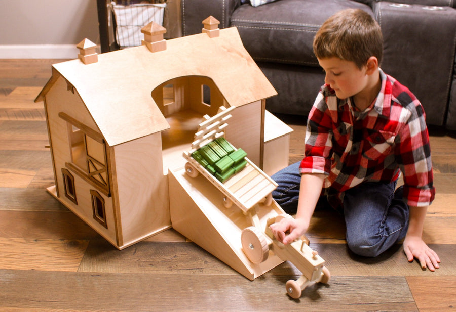 Child playing with a two-story wooden bank barn