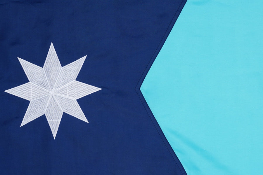 Minnesota state flag close-up with white eight-point star and blue field