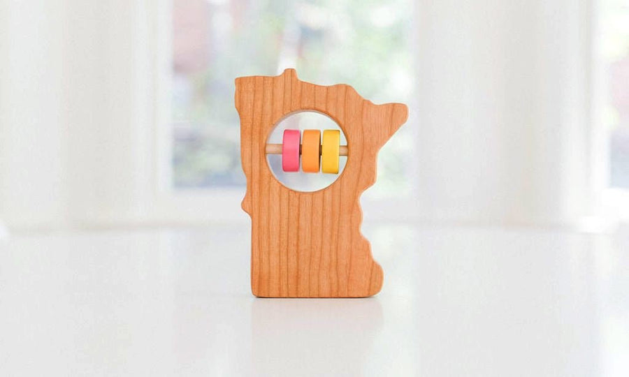 Minnesota state-shaped cherry wood baby rattle with colored center disks