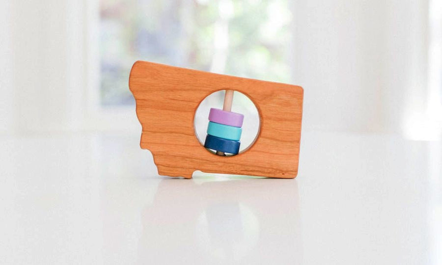 Montana state-shaped cherry wood baby rattle with colored center disks