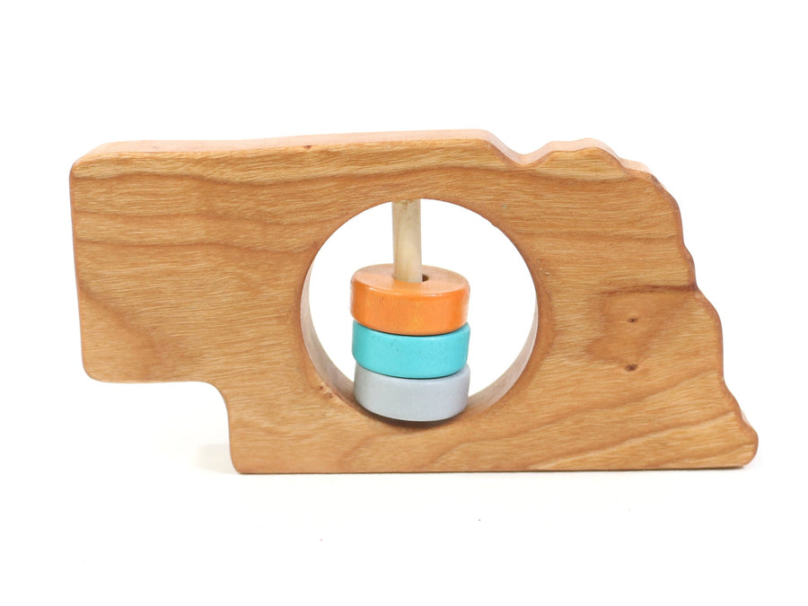 Nebraska state-shaped cherry wood baby rattle with colored center disks