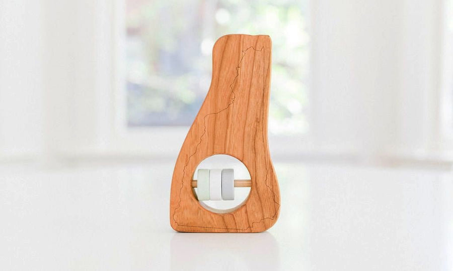 New Hampshire state-shaped cherry wood baby rattle with colored center disks