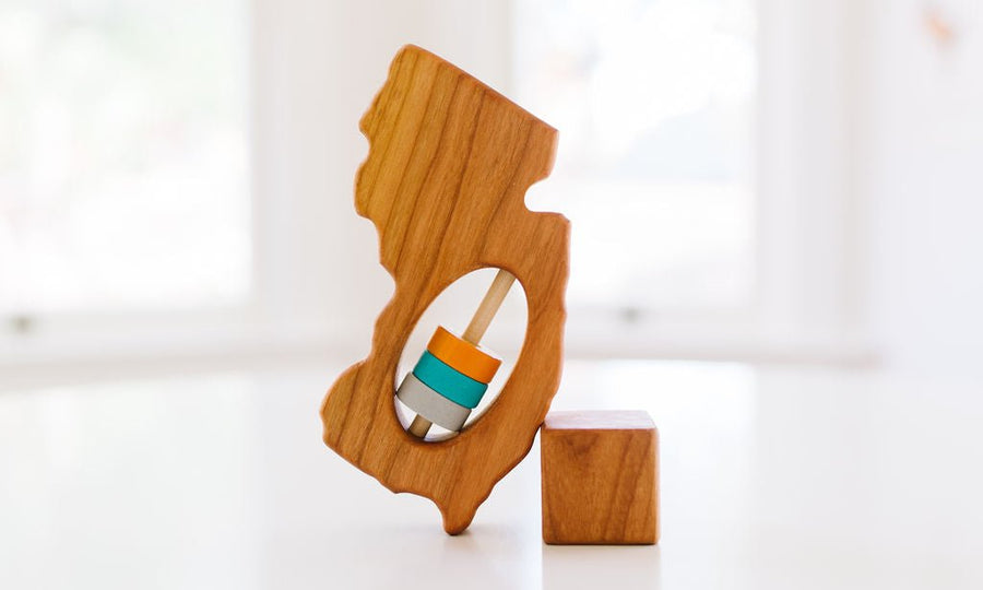 New Jersey state-shaped cherry wood baby rattle with colored center disks